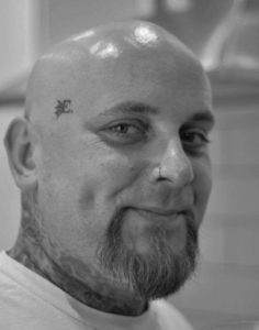 Tattoo artist mid-session working on large back piece in Essex studio