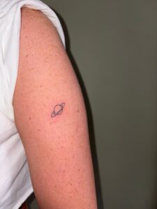 Dainty Tattoos in Essex done on the arm, small planet