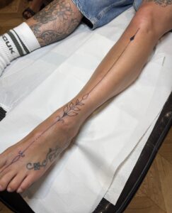 image of a leg with a straight line tattoos running down the shin from our Chelmsford tattoo studio. Linework Tattoo Artist in Essex